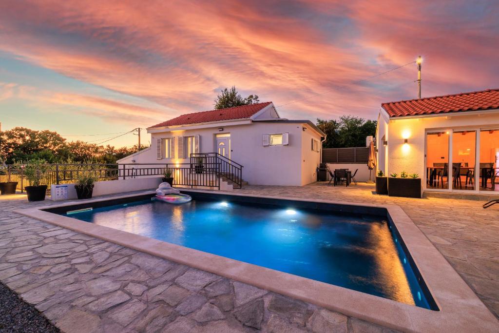 a swimming pool in front of a house at House Scaena in Jadranovo
