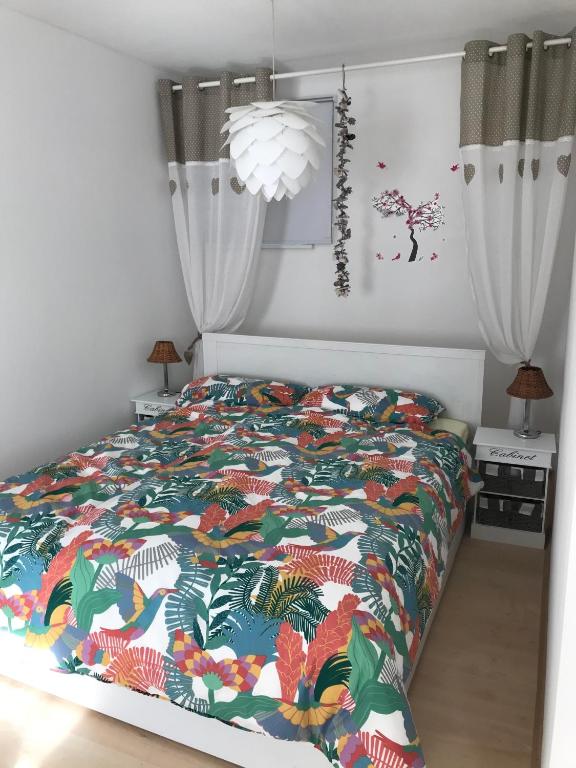 a bedroom with a bed with a colorful comforter at Ferienwohnung Udenheim in Udenheim