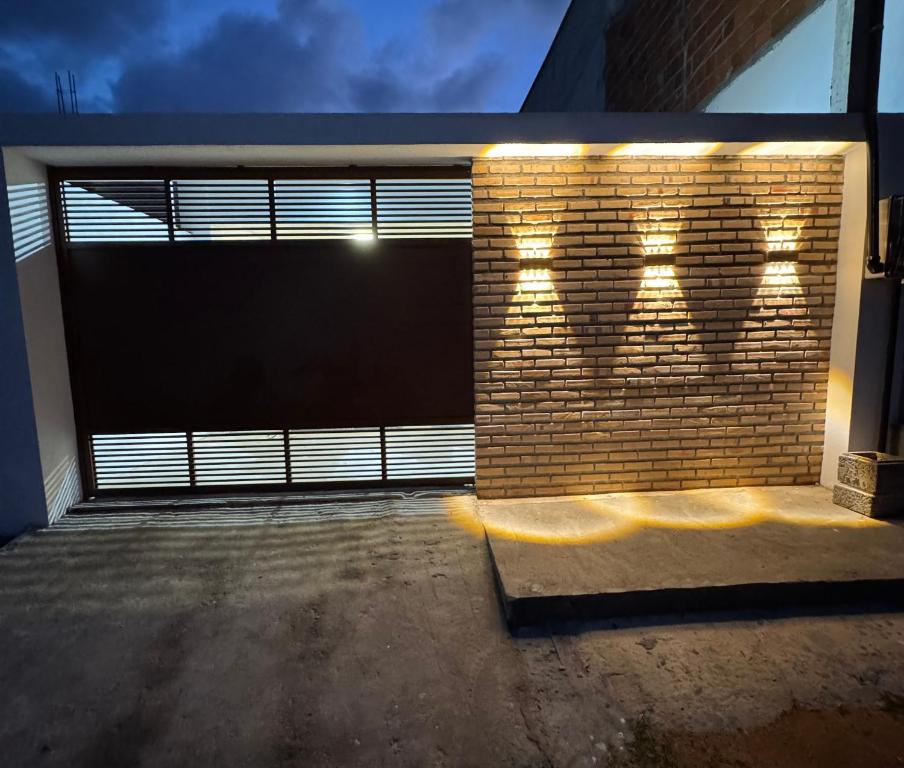 a garage with a brick wall with lights on it at Casa Alvorada in Flecheiras