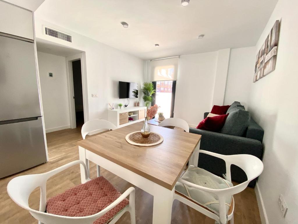 Una cocina y una sala de estar con mesa y sillas. en Novamar Apartamentos, en Fuengirola