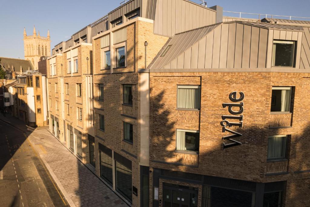un edificio di mattoni con un cartello sul lato di Wilde Aparthotels Cambridge City Centre a Cambridge