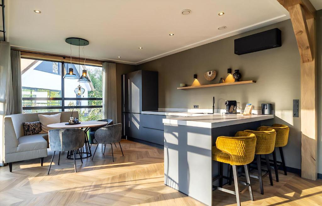 a kitchen with a bar and a table and chairs at H-1 Buytenveldt in De Cocksdorp