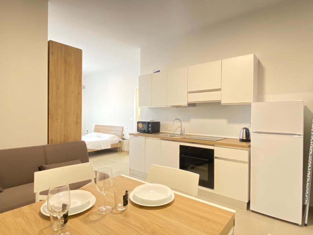 a kitchen with a table and a white refrigerator at Suite Emilia 2 in Bologna