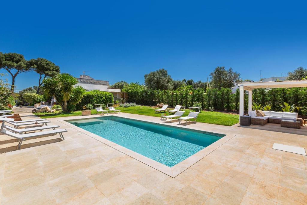 - une piscine dans un jardin avec des chaises longues dans l'établissement Casal 800 by Perle di Puglia, à Ostuni