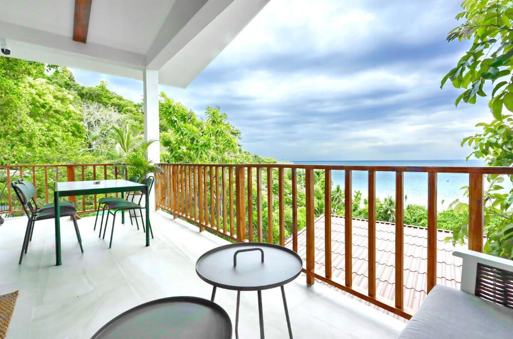 a balcony with a table and chairs and the ocean at Haad Yao Villa 13 Luxury Sea View & Pool in Koh Phangan