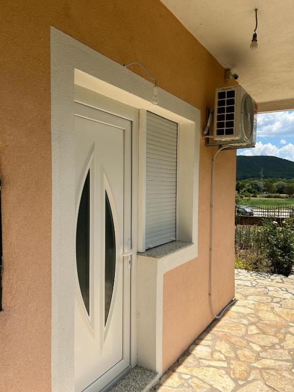 a door to a house with a window and a fan at Apartman GUŠI in Knin
