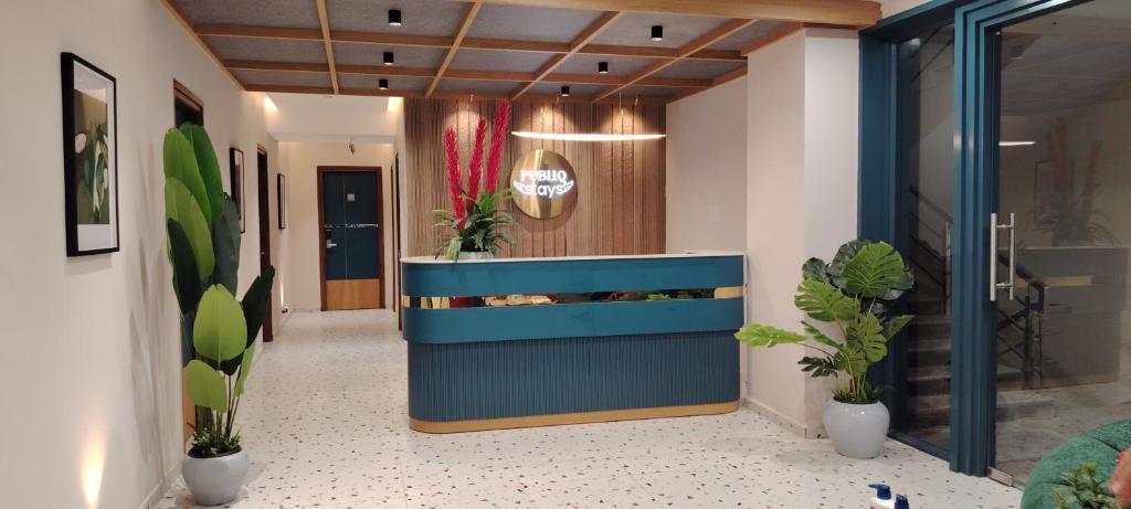 a lobby with a blue bench and potted plants at PubliQ Luxury Stays in Hyderabad