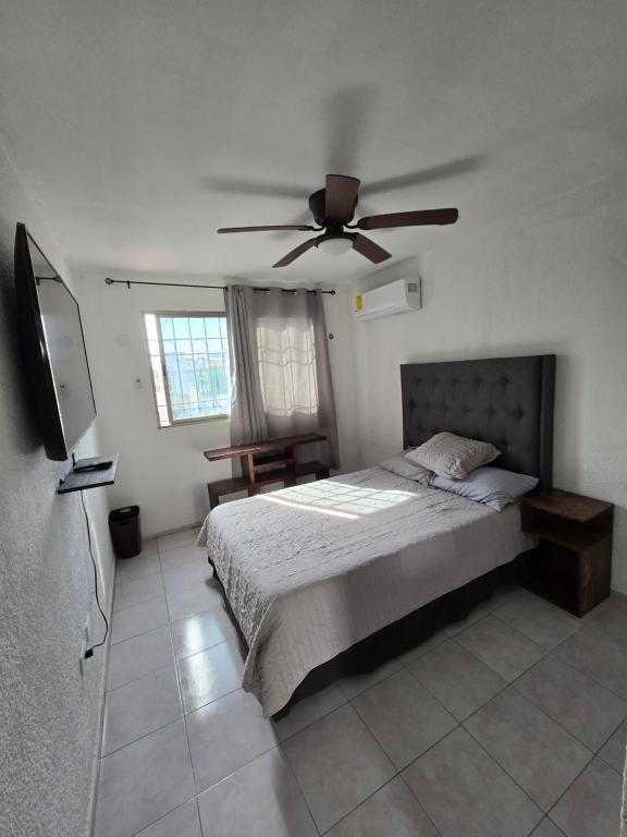 a bedroom with a bed with a ceiling fan at Comoda Suite Privada in Cancún