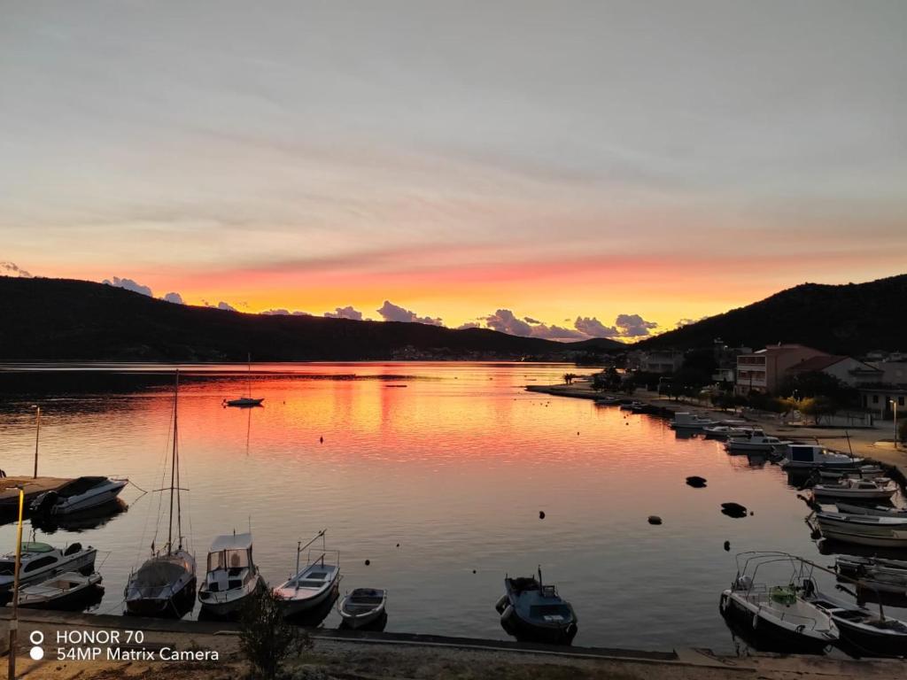 a group of boats docked in a marina at sunset at Sea View Apartment Sunrise Poljica & Blue Lagoon Rent A Boat in Poljica