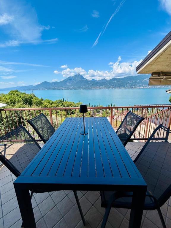 a blue table and chairs on a balcony with a view of the water at Appartamento Pelèr in Pai