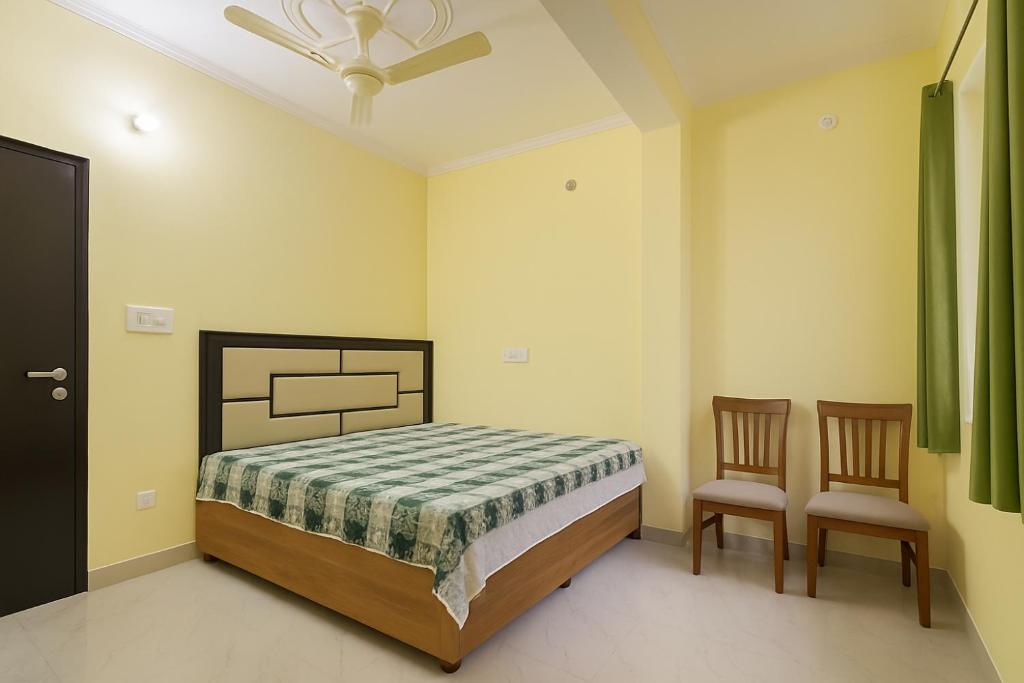 DarlaghatThe Serene Corner的一间卧室，里面有一张床和两把椅子