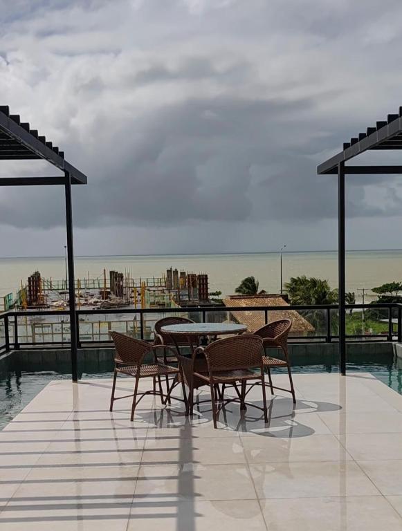 a patio with a table and chairs on a roof at Flat Studio in João Pessoa