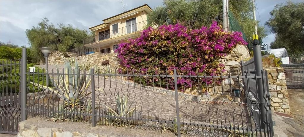 a fence in front of a house with purple flowers at Casa Margherita in Pairola