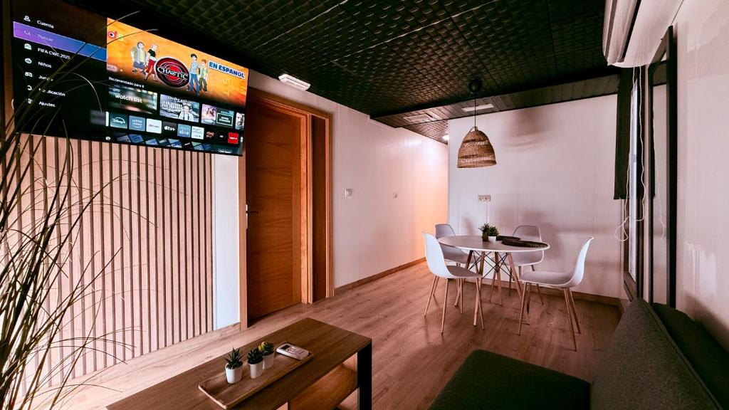 a dining room with a table and white chairs at Apartamentos villa Carolina in Porriño