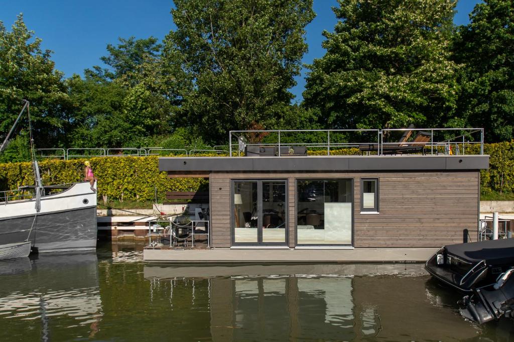 a small house on a boat in the water at ANKERLOFT - Hausboot in Hannover
