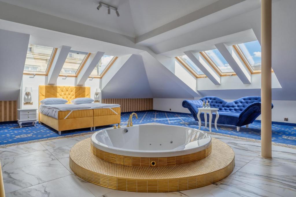 a large room with a tub and a bed at Czeczotka Palace Apartments in Kraków