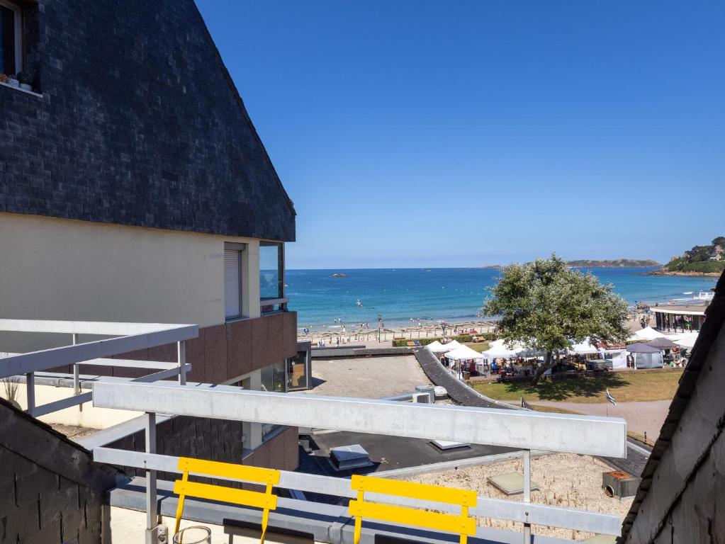 a view of the beach from a building with yellow benches at Ty Fox by Madame est Servie in Perros-Guirec