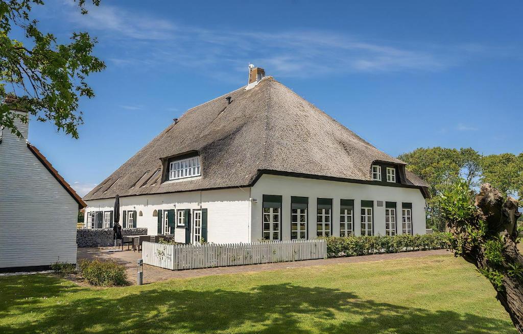 una casa con techo de paja en un patio en T-4 Hoeve Holland, en De Cocksdorp