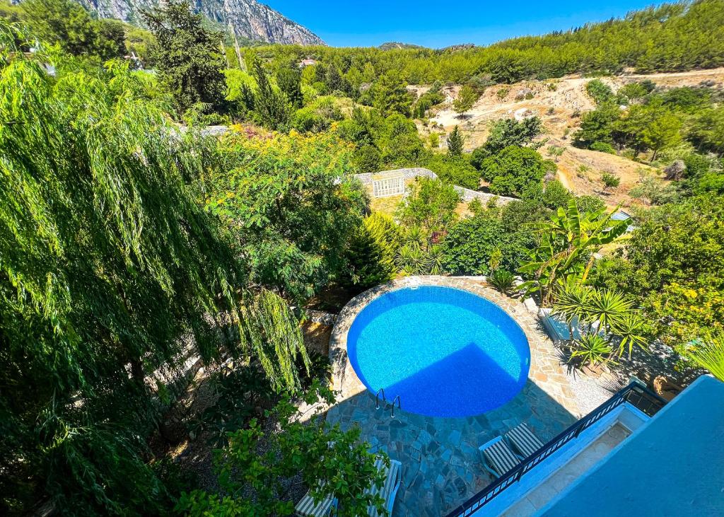 an overhead view of a swimming pool with trees and mountains at Luxurious Villa Beckham by HolidayKeys in Kérynia