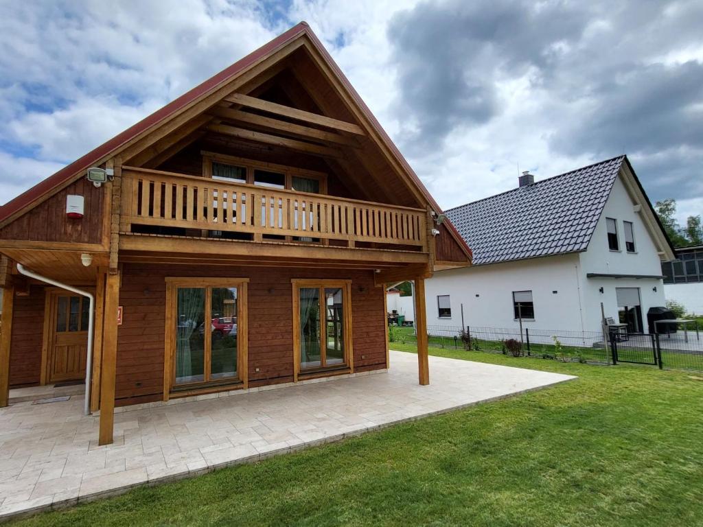 KleinkörisにあるChalet Seeblick 21 by Interhomeの芝生の上にデッキがある大きな木造家屋