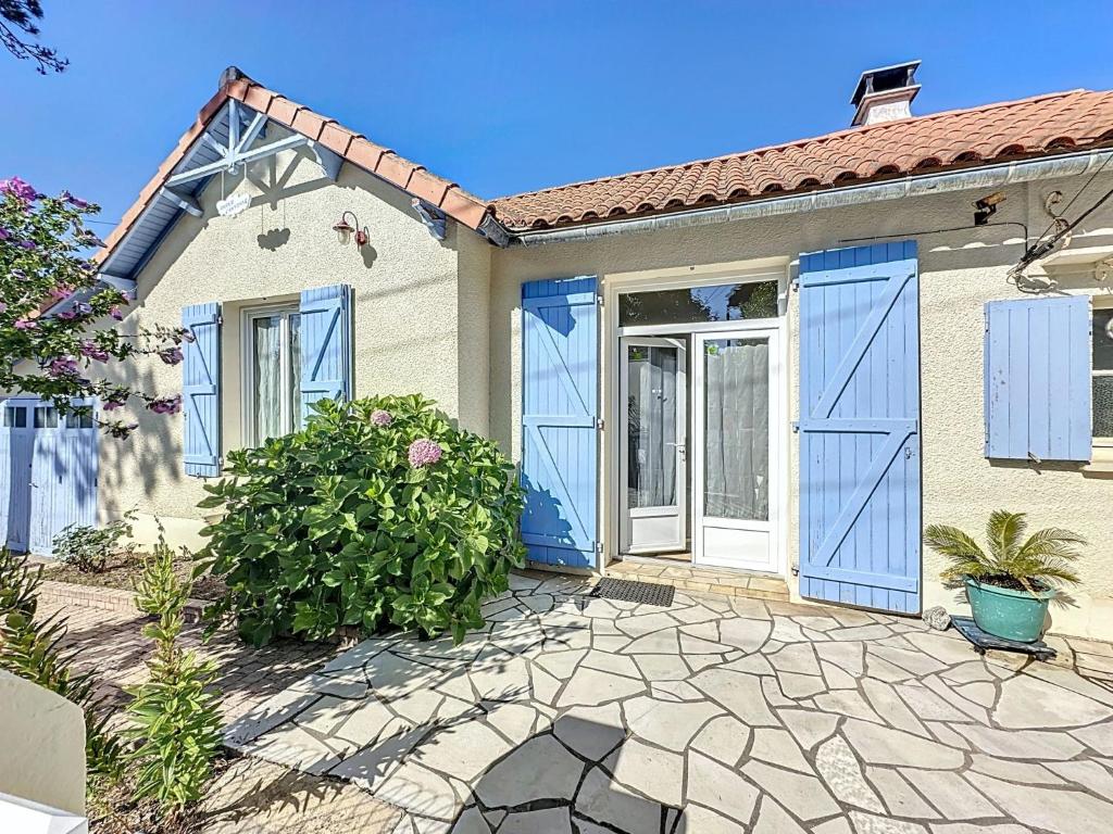 a house with blue doors and a patio at Holiday Home Les Volets Bleus by Interhome in Tharon-Plage