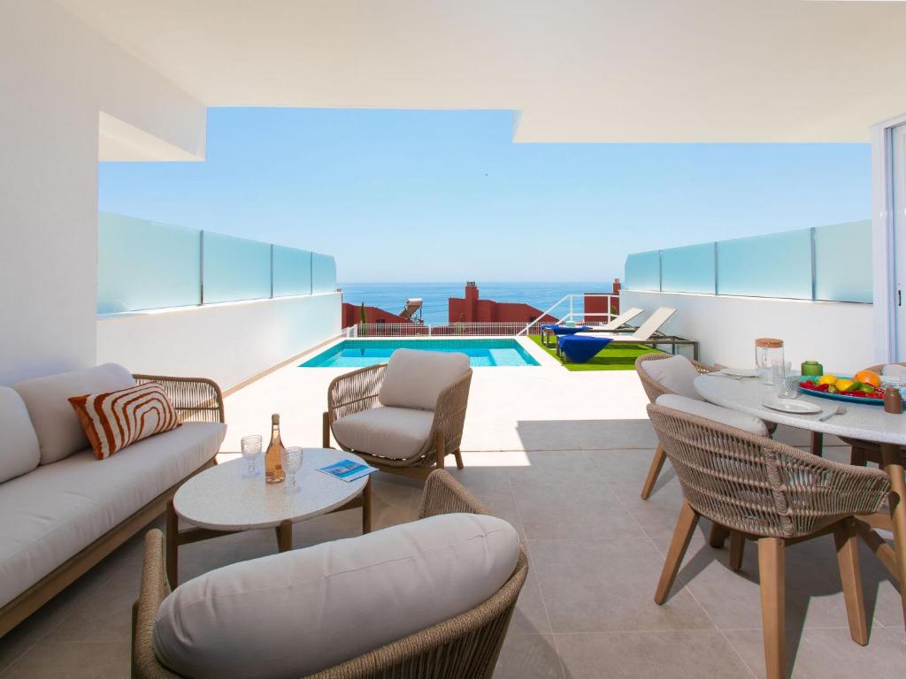 a living room with a couch and chairs and a pool at Apartment Bayviewhills Amazing Spa & Padel by Interhome in Torrox Costa