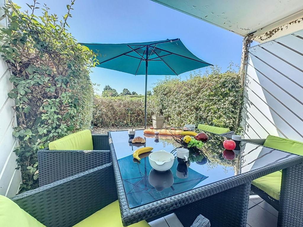 einen Tisch auf einem Balkon mit Sonnenschirm in der Unterkunft Apartment L'Orée du Golf-3 by Interhome in Pornic