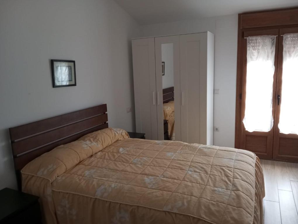 a bedroom with a bed and a door to a closet at Habitaciones para dormir in Vadocondes