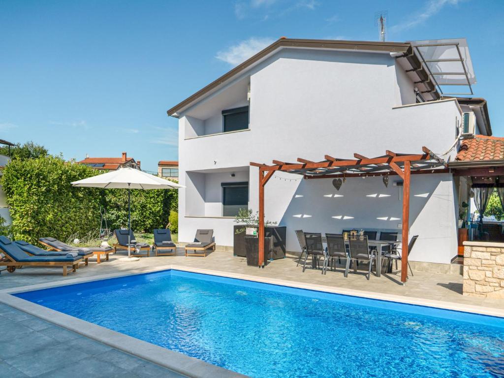 a villa with a swimming pool and a house at Holiday Home Gabi by Interhome in Brtonigla