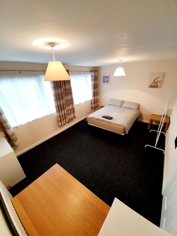 een slaapkamer met een bed en twee ramen bij 4 Bedroom Rayleigh Town House in Rayleigh