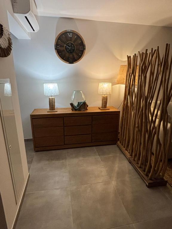 a living room with a clock on the wall at A Isula Paradisu - Classé 4 étoiles in LʼÎle-Rousse