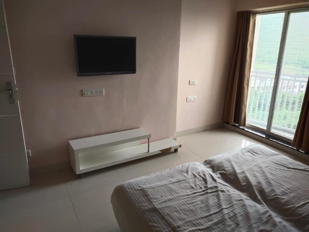 Un dormitorio con una cama y un televisor en la pared. en GG Homes, en Udaipur