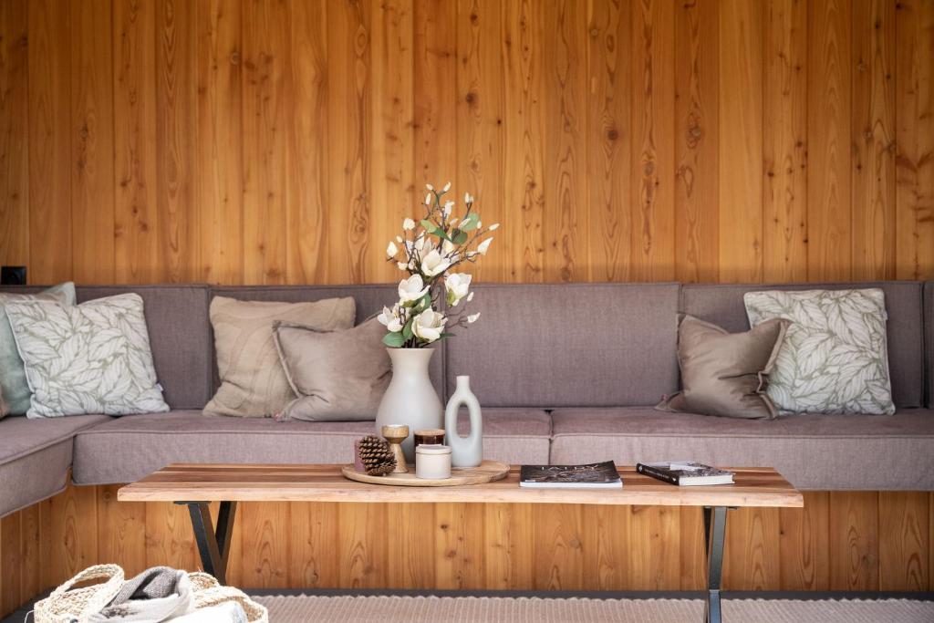 a living room with a couch and a table with flowers at Willa Podhalanka Jacuzzi & sauna - drewniany dom dla 20 osób in Biały Dunajec
