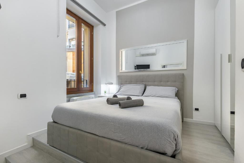 a bedroom with a bed with two towels on it at White APT - Duomo - 6 posti in Milan