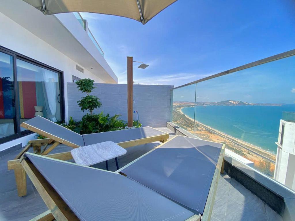 ムイネーにあるHala Beachfront Condotel Mui Neのテーブルと椅子と海のあるバルコニー