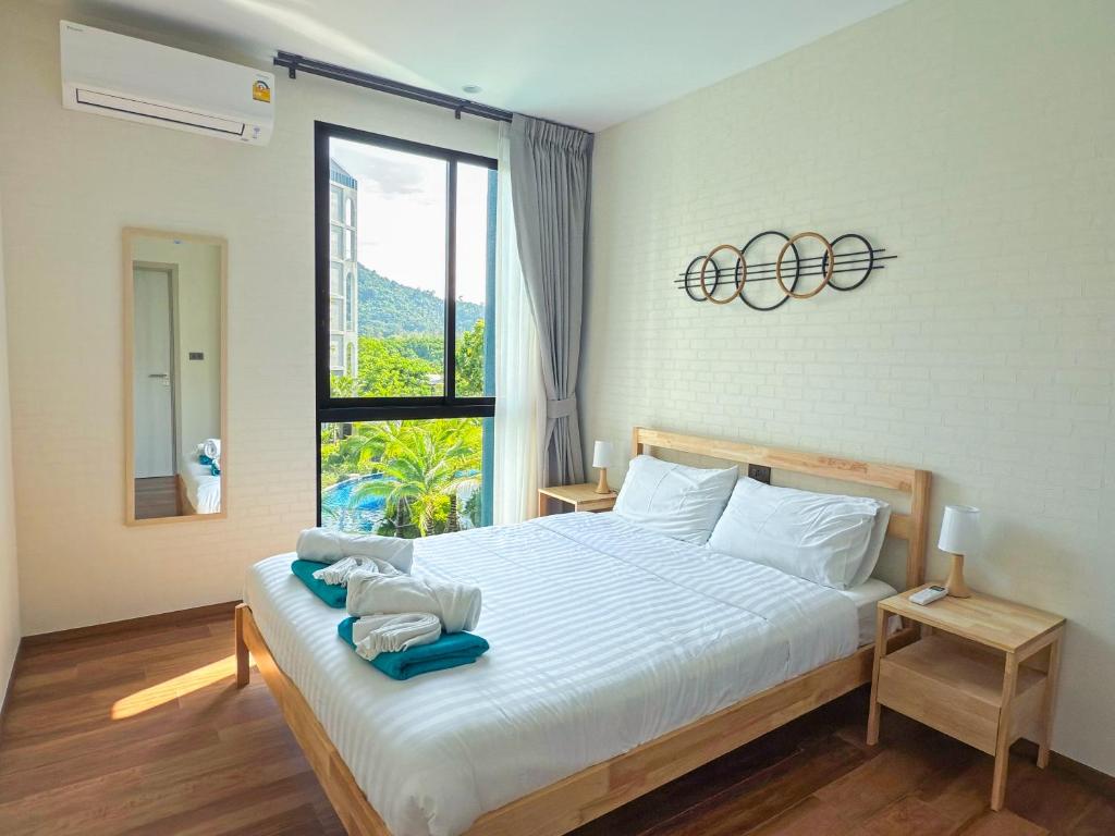 a bedroom with a bed and a large window at The Title Halo1 2BD by MILL in Phuket