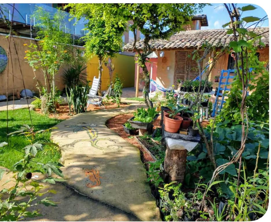 een tuin met een loopbrug voor een huis bij Recanto de Gaia in Ilhabela