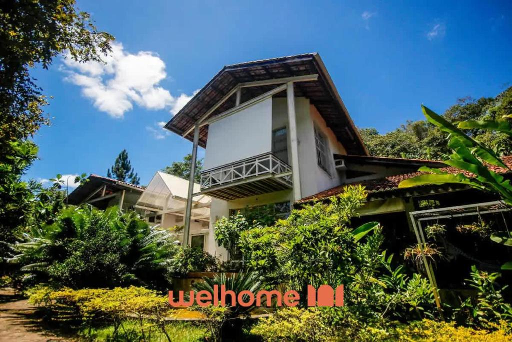 a house with a balcony on top of it at Casa em Guaramiranga com Piscina Coberta in Guaramiranga