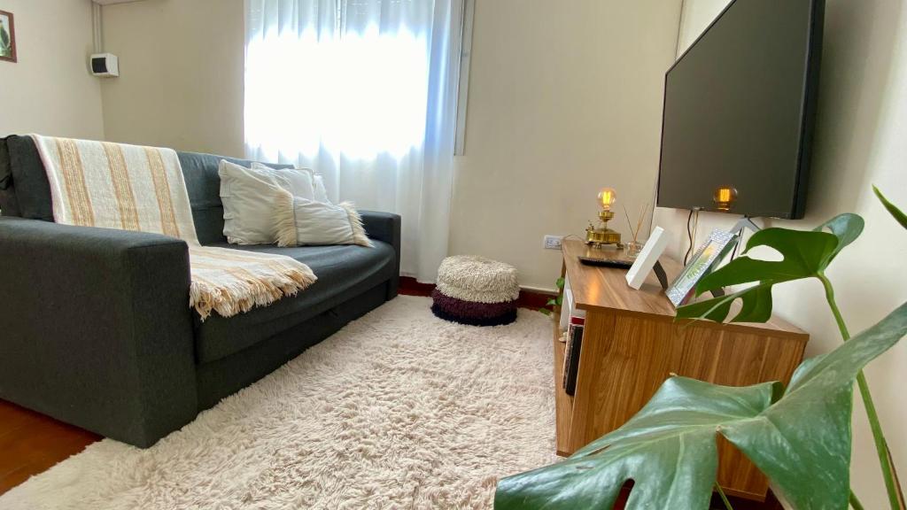 un soggiorno con un divano e una TV di Aloha Teo - Departamento por Día en Trelew, espacioso y cerca de todo! a Trelew
