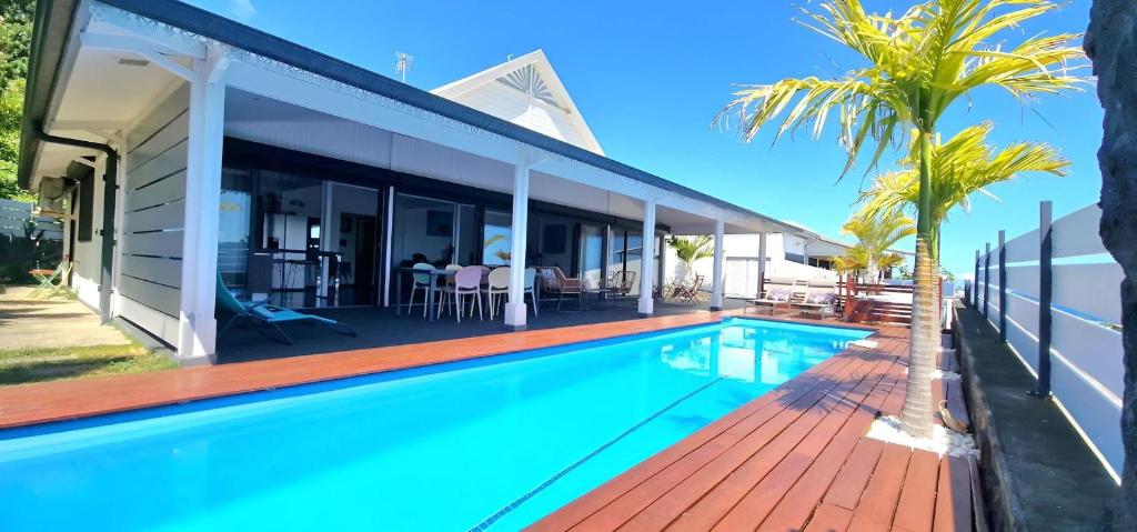 a swimming pool in front of a house at Villa Rêve Austral in Grands Bois