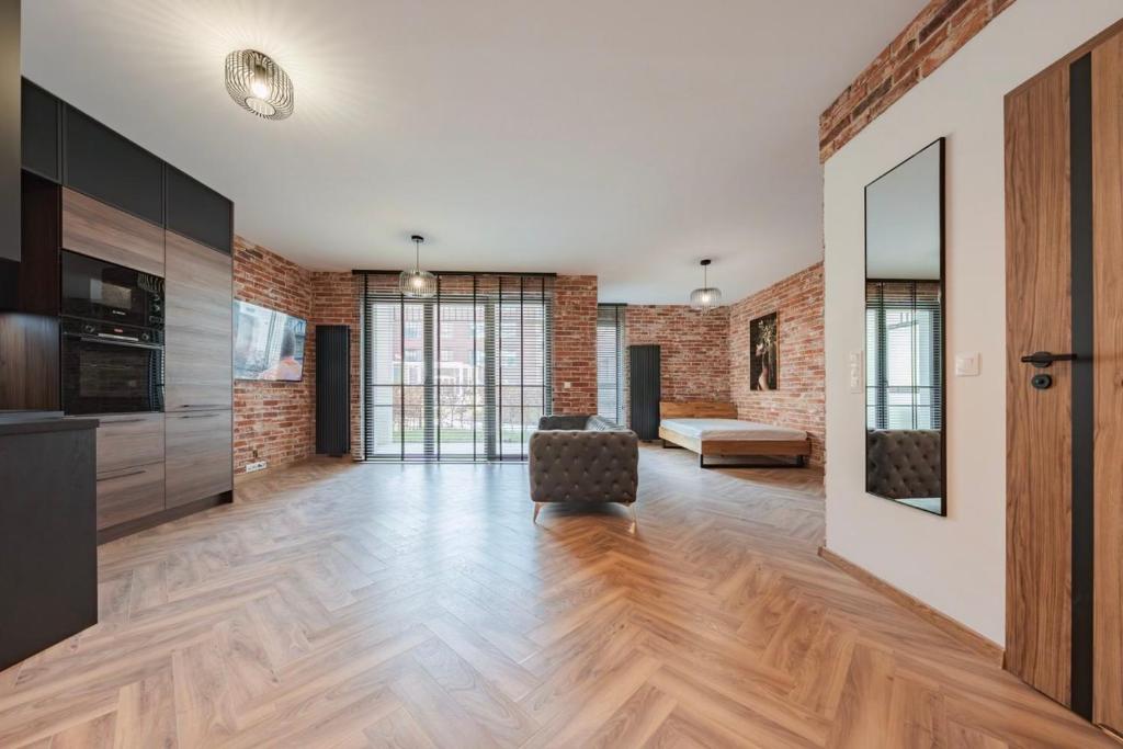 un salon avec une chaise et un mur de briques dans l'établissement Apartament Loft & glow Montownia, à Gdańsk