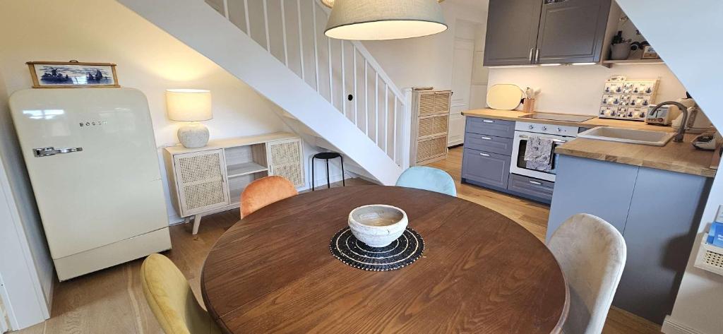 a kitchen with a wooden table and a kitchen with a stair at Amrum Lounge - Stilvolle Ferienwohnung mit Gartenidylle in Nebel