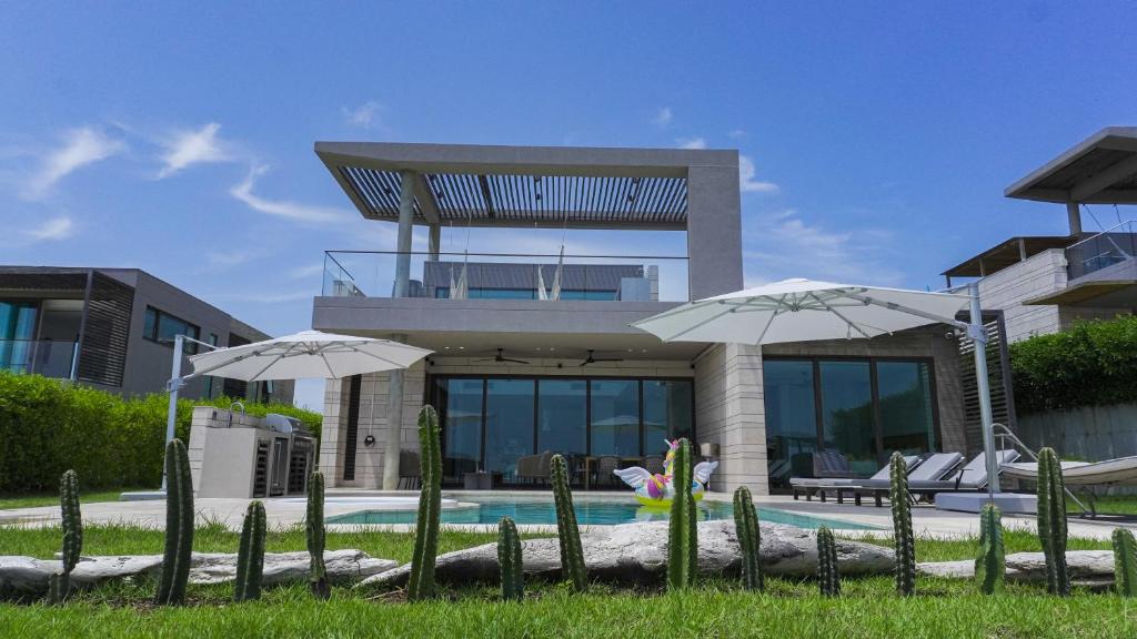 a house with a swimming pool and two umbrellas at Villa Puerta- Luxury Seaside Villa in Pendales