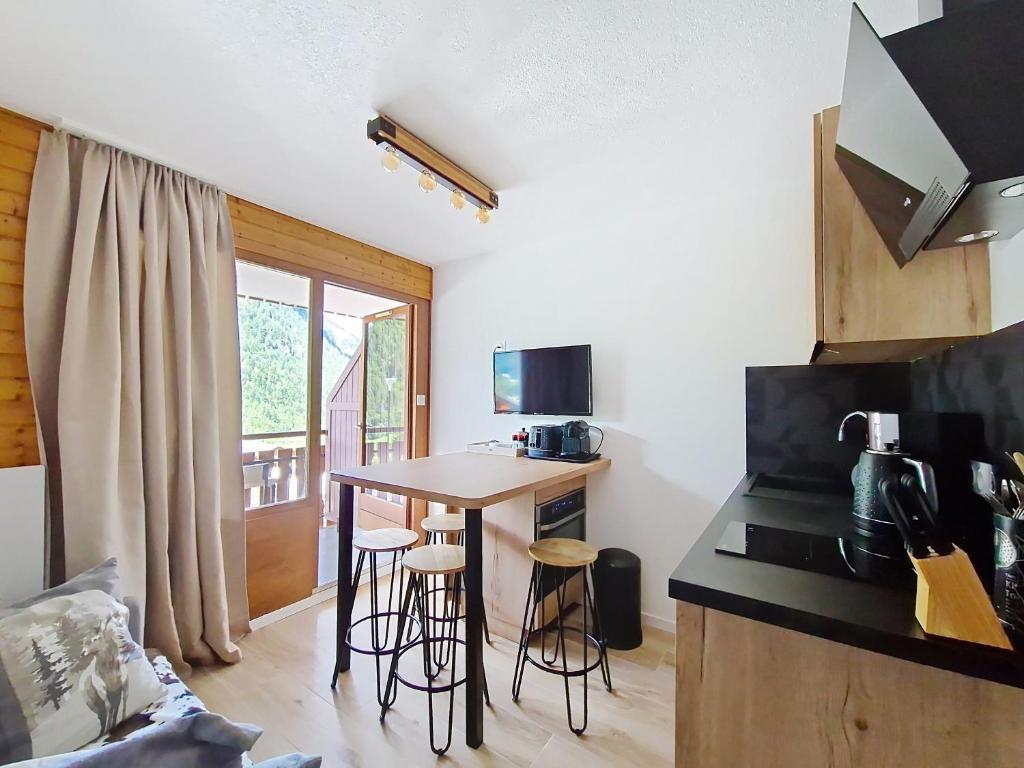 シャテルにあるToison Blanche TBA3 COSY & Mountain 4 Persの部屋にテーブルとスツールが置かれたキッチン