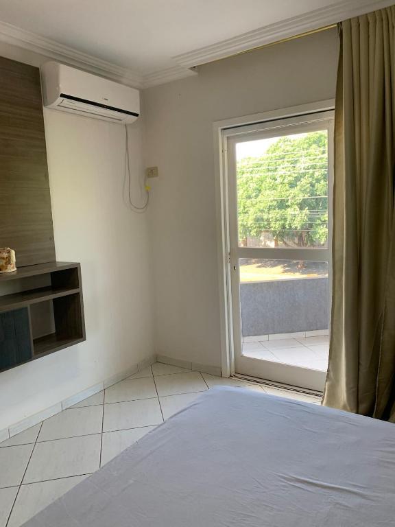 Dieses weiße Zimmer verfügt über ein Fenster und ein Bett. in der Unterkunft Crisálidas experience in Foz do Iguaçu