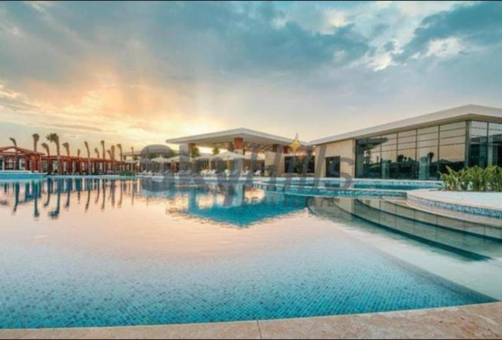 ein Resort mit einem großen Pool mit einem Gebäude in der Unterkunft Swanlake Lagoon Luxury Villa in Zāwiyat al ‘Awwāmah