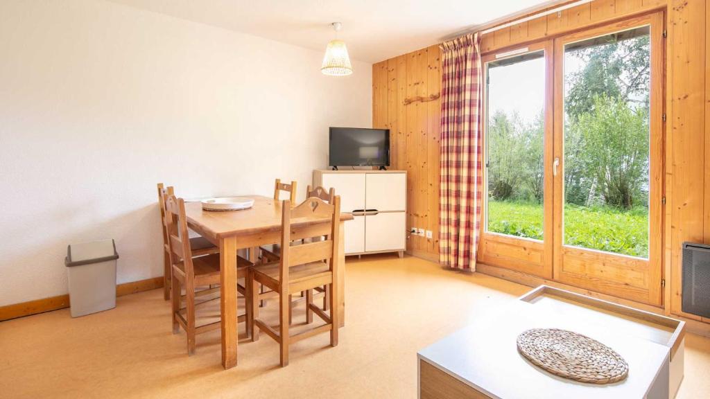a living room with a table and chairs and a television at Les Grizzlis N 20 - 2P6 in Saint-Sorlin-dʼArves