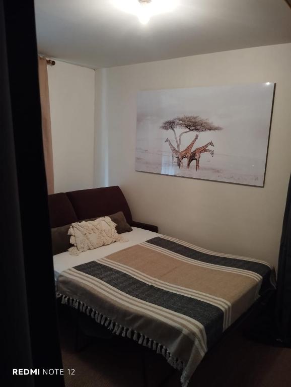 a bed in a room with a painting on the wall at Espaço brasserie in Noyon