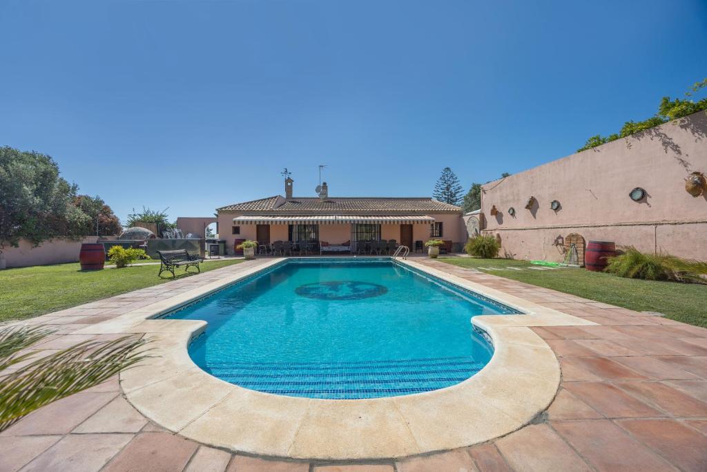 ein Swimmingpool vor einem Haus in der Unterkunft Casa Con Jardín y piscina in Chiclana de la Frontera