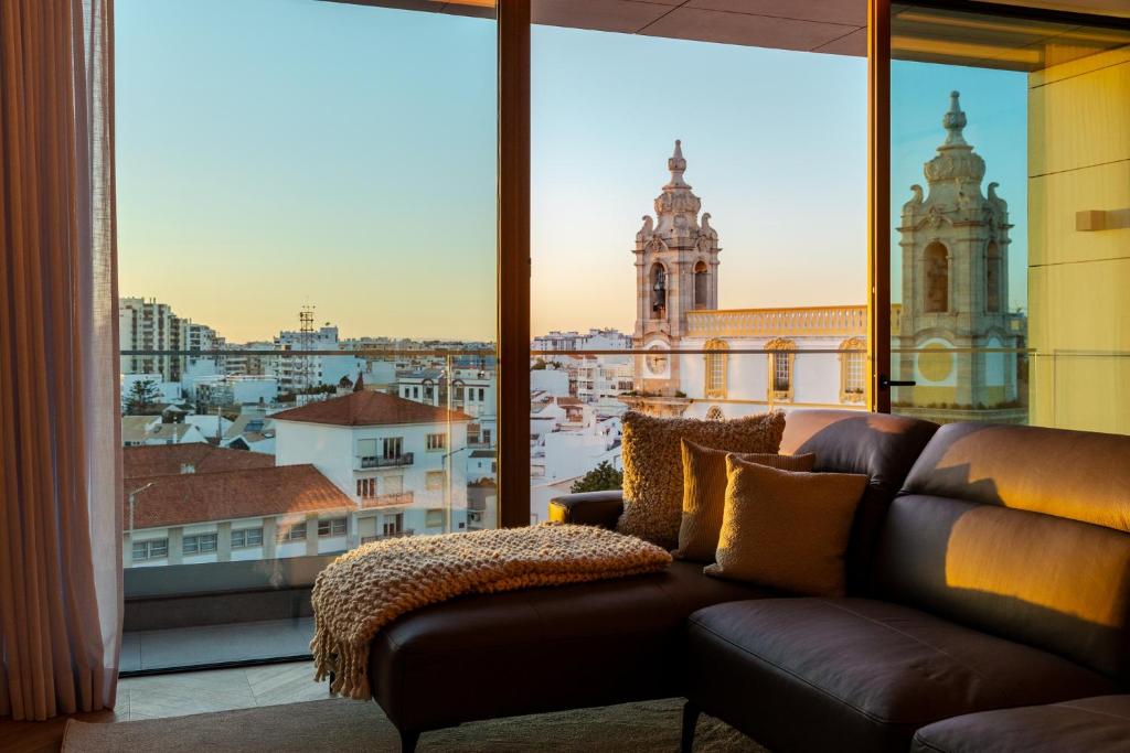 a couch in a room with a large window at The View at The Downtown Faro in Faro